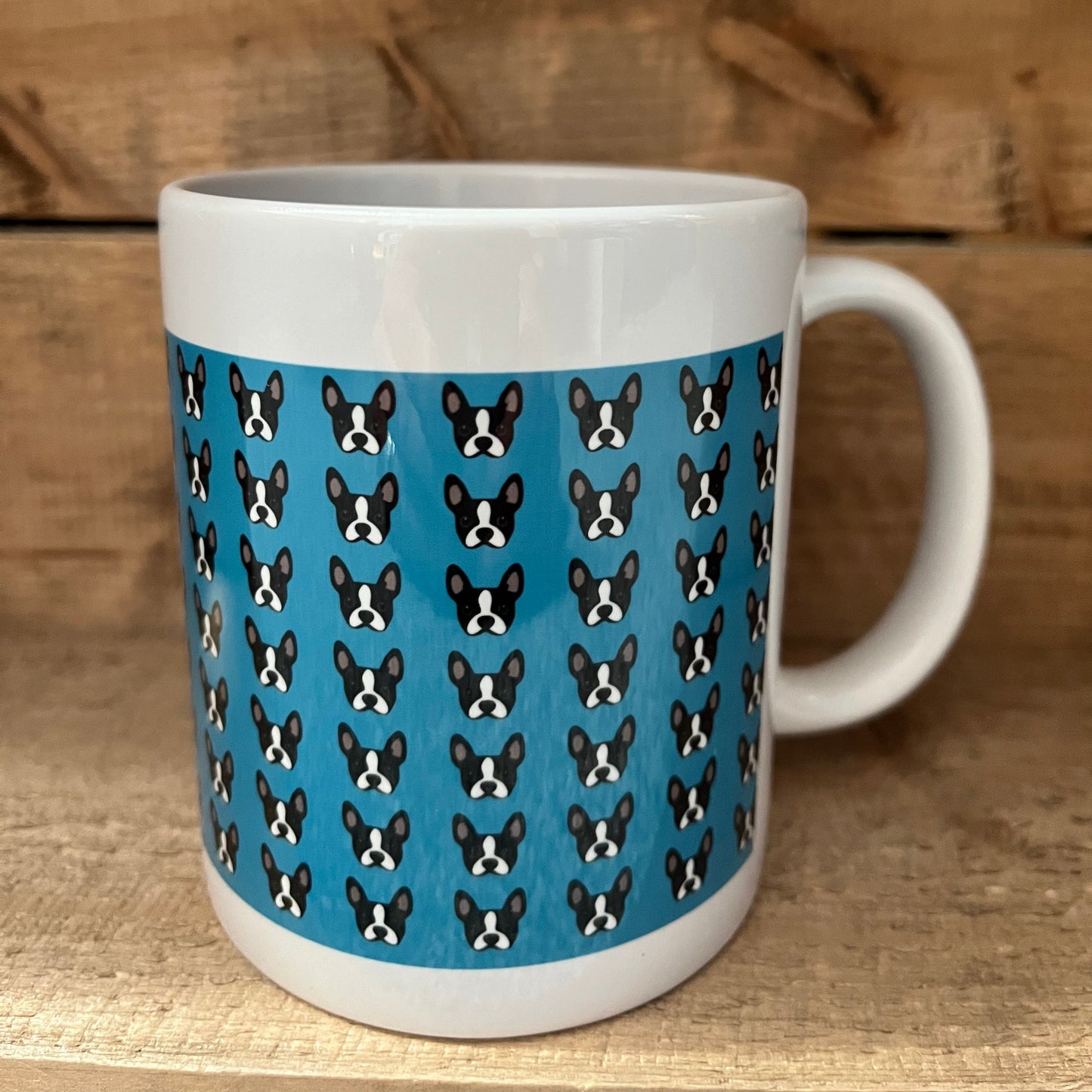 Mug with a blue pattern of black and white dogs on a wooden surface
