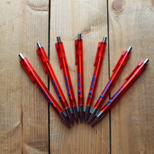 Red pens with black accents arranged on a wooden surface